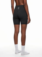 CLAiRE Women's High-Waisted Biker Shorts in Black, back three-quarter view.