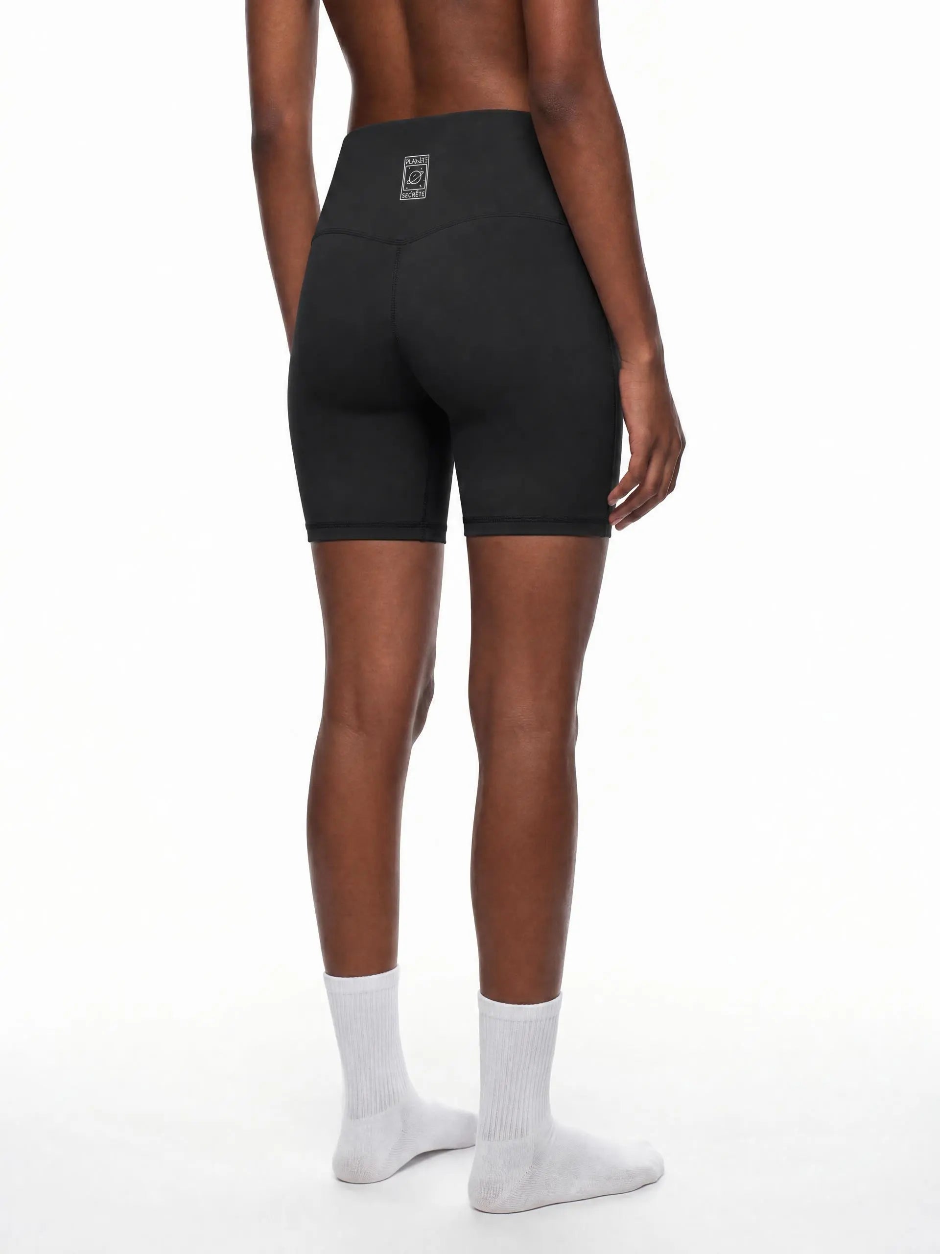 CLAiRE Women's High-Waisted Biker Shorts in Black, back three-quarter view.
