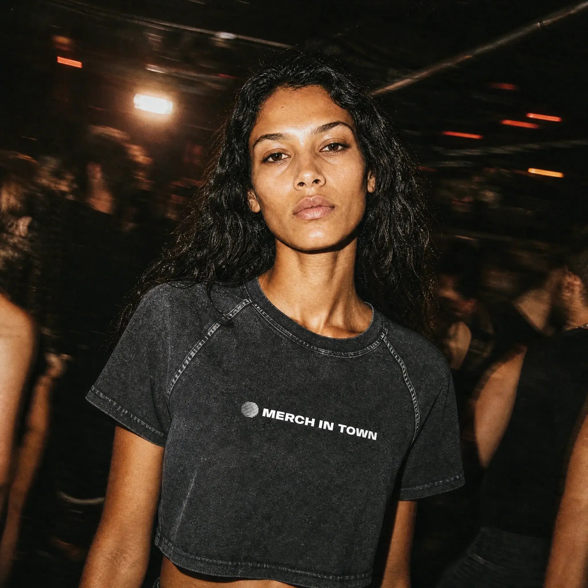 Merch in Town Women's Mineral Wash Raglan Crop T-Shirt in Black, front lifestyle shot