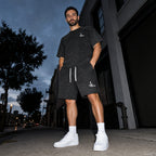 Salon Daomé black mineral wash raw edge t-shirt and matching shorts worn together on a city street.