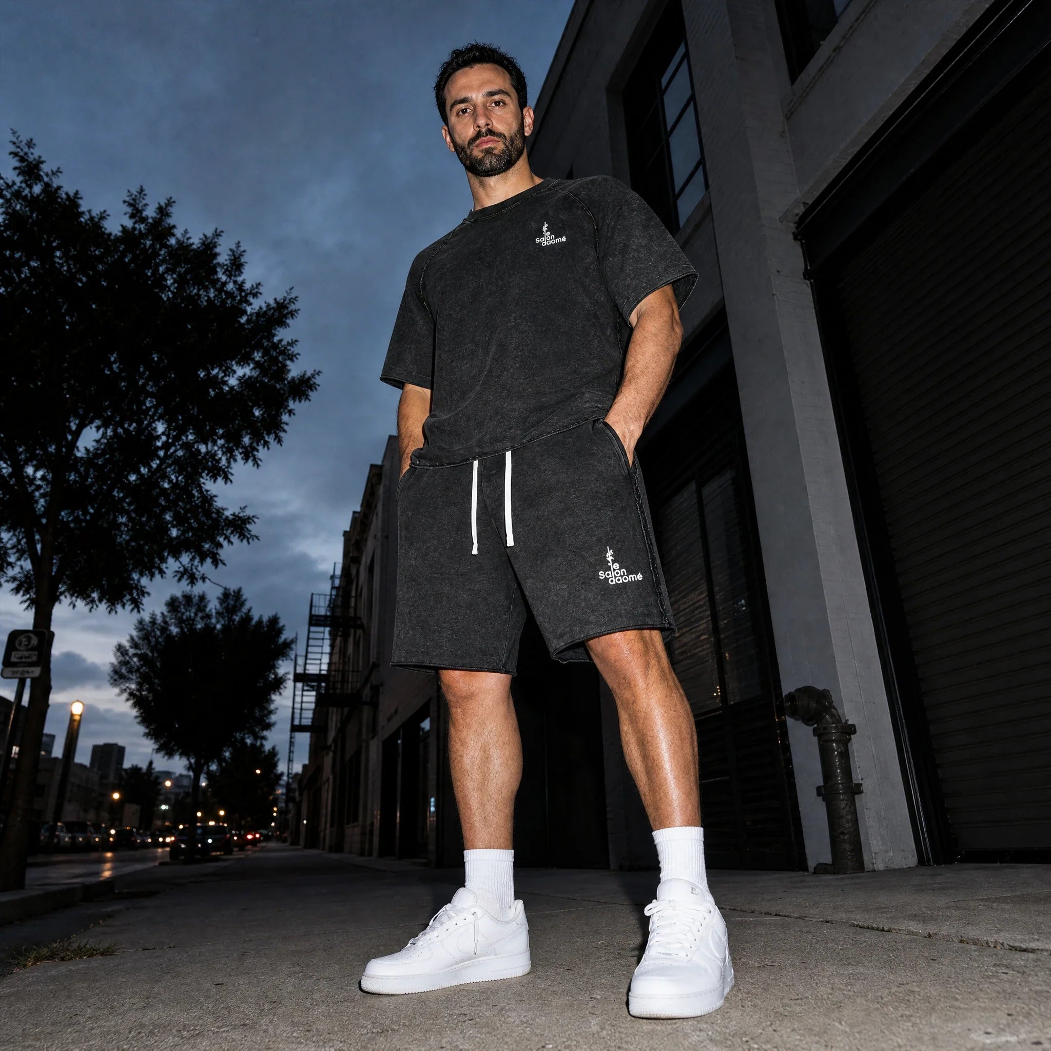 Salon Daomé black mineral wash raw edge t-shirt and matching shorts worn together on a city street.