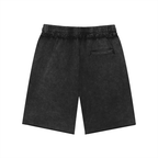 Salon Daomé black mineral wash raw edge shorts on a white background, back view.