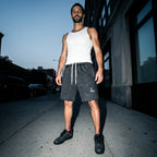 Salon Daomé mineral wash raw edge shorts in medium gray worn with a white tank on a city sidewalk.