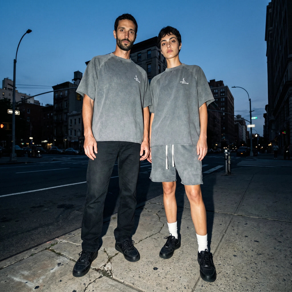 Two people wearing the Salon Daomé mineral wash raw edge t-shirt in medium gray on a city street.