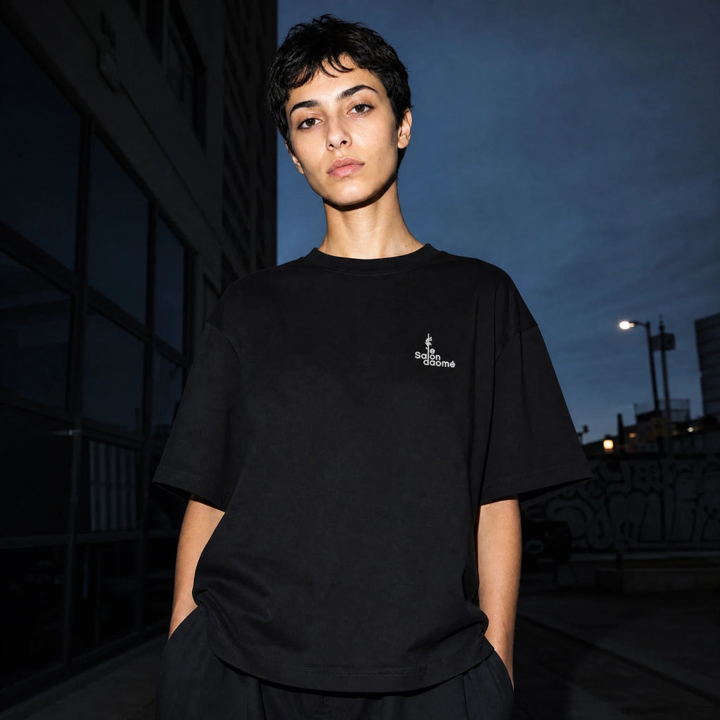 Salon Daomé black Sorona quick-dry boxy t-shirt worn on a city street at night.
