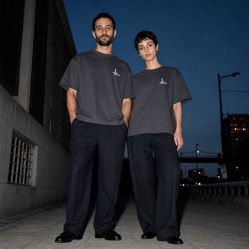 Two people wearing the Salon Daomé dark purple Sorona boxy t-shirt with tailored trousers at dusk.