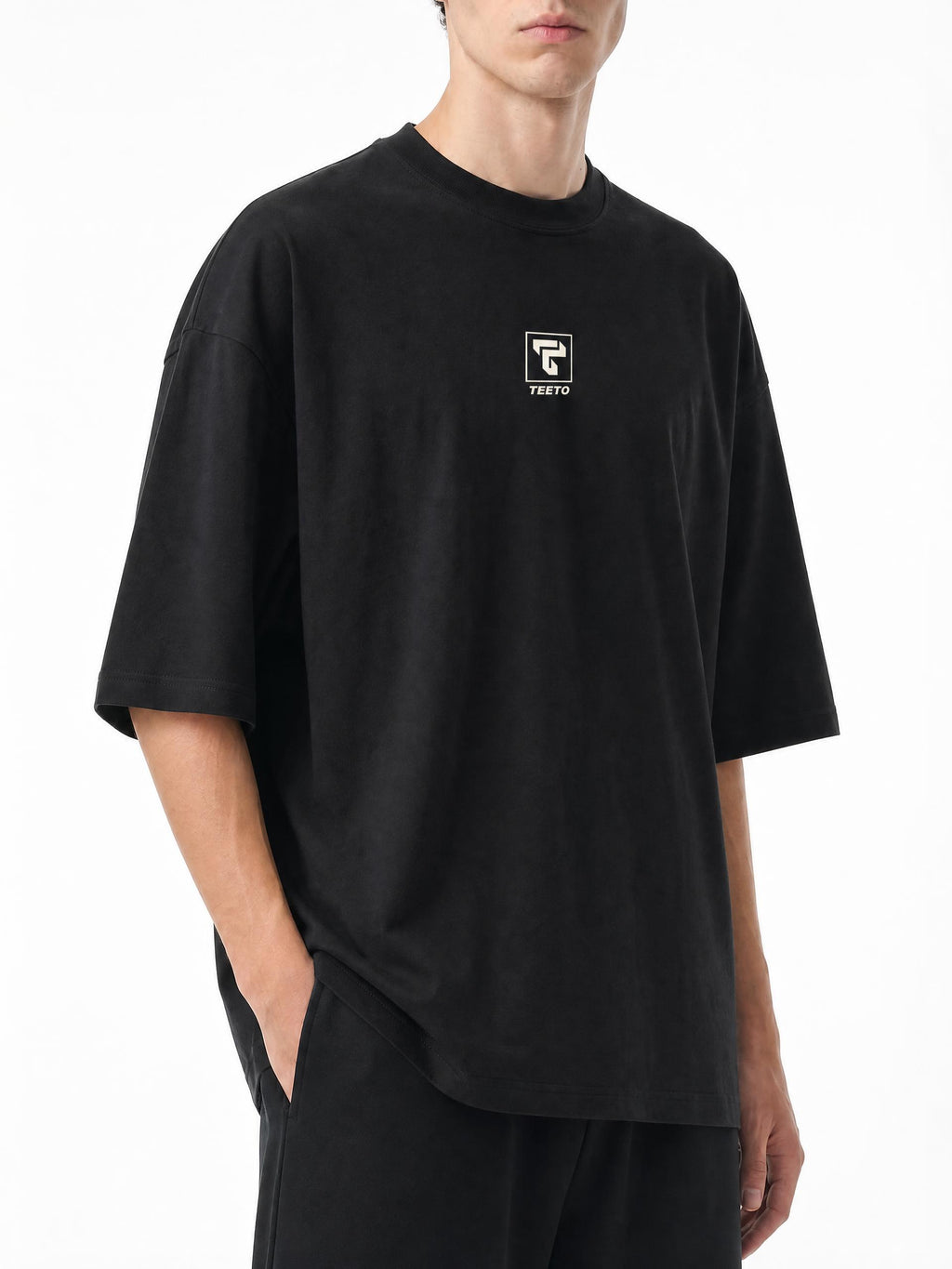 Teeto Oversized Drop Shoulder T-Shirt in Black worn by a model, front three-quarter view.