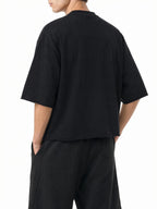 Teeto Mineral Wash Raw Hem Boxy T-Shirt in Black worn by a model, back view.