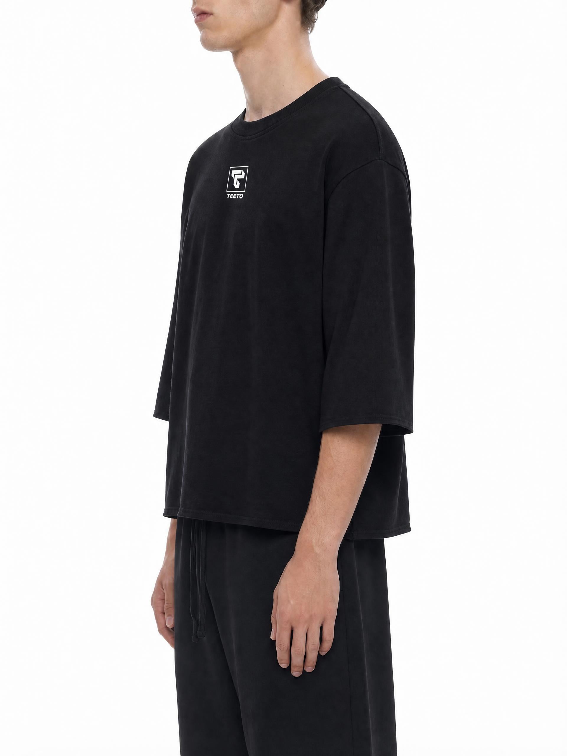 Teeto Mineral Wash Raw Hem Boxy T-Shirt in Black worn by a model, side view.