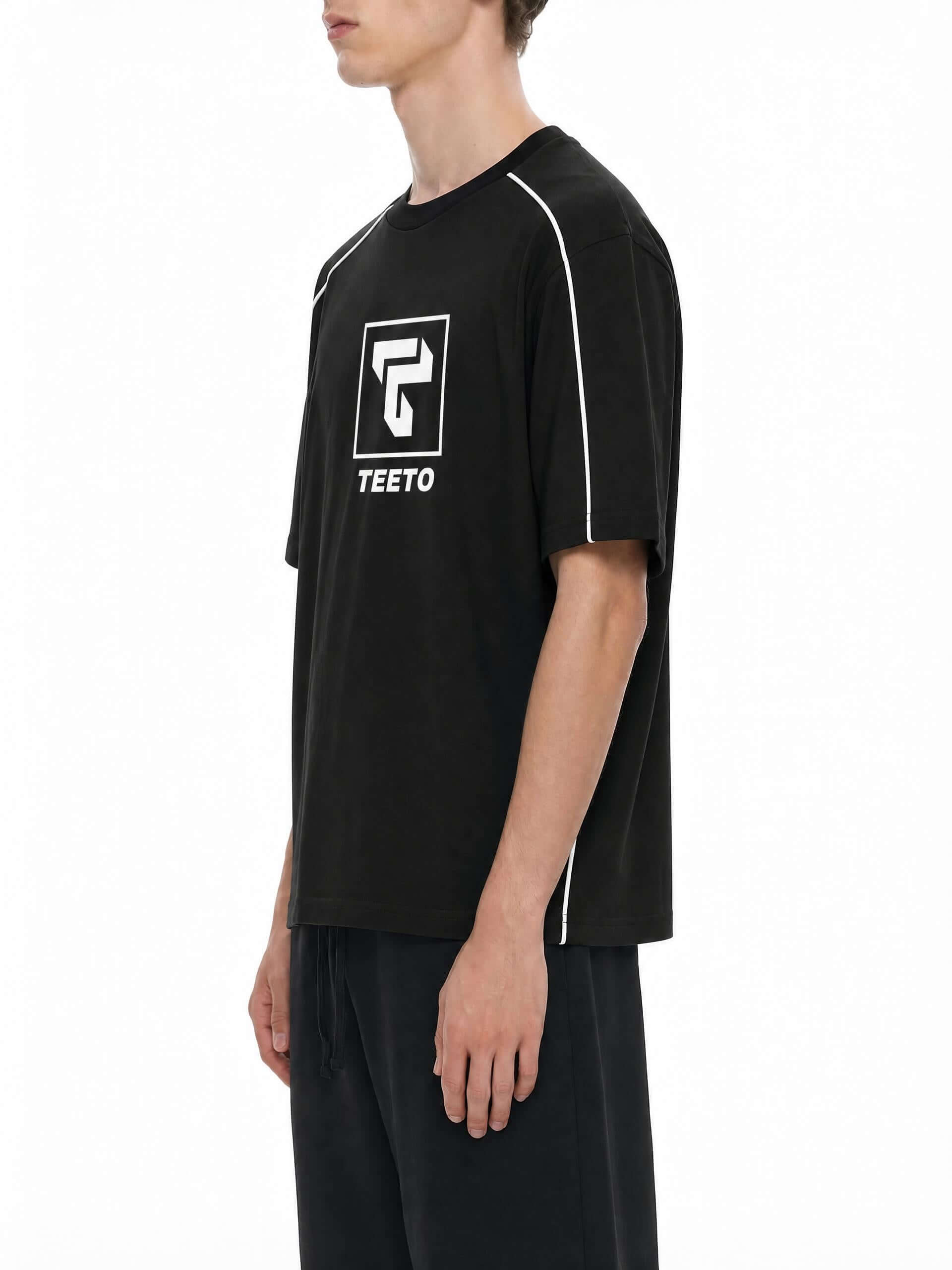 Teeto Heavyweight Boxy Piping T-Shirt in Black worn by a model, front three-quarter view, alternate.