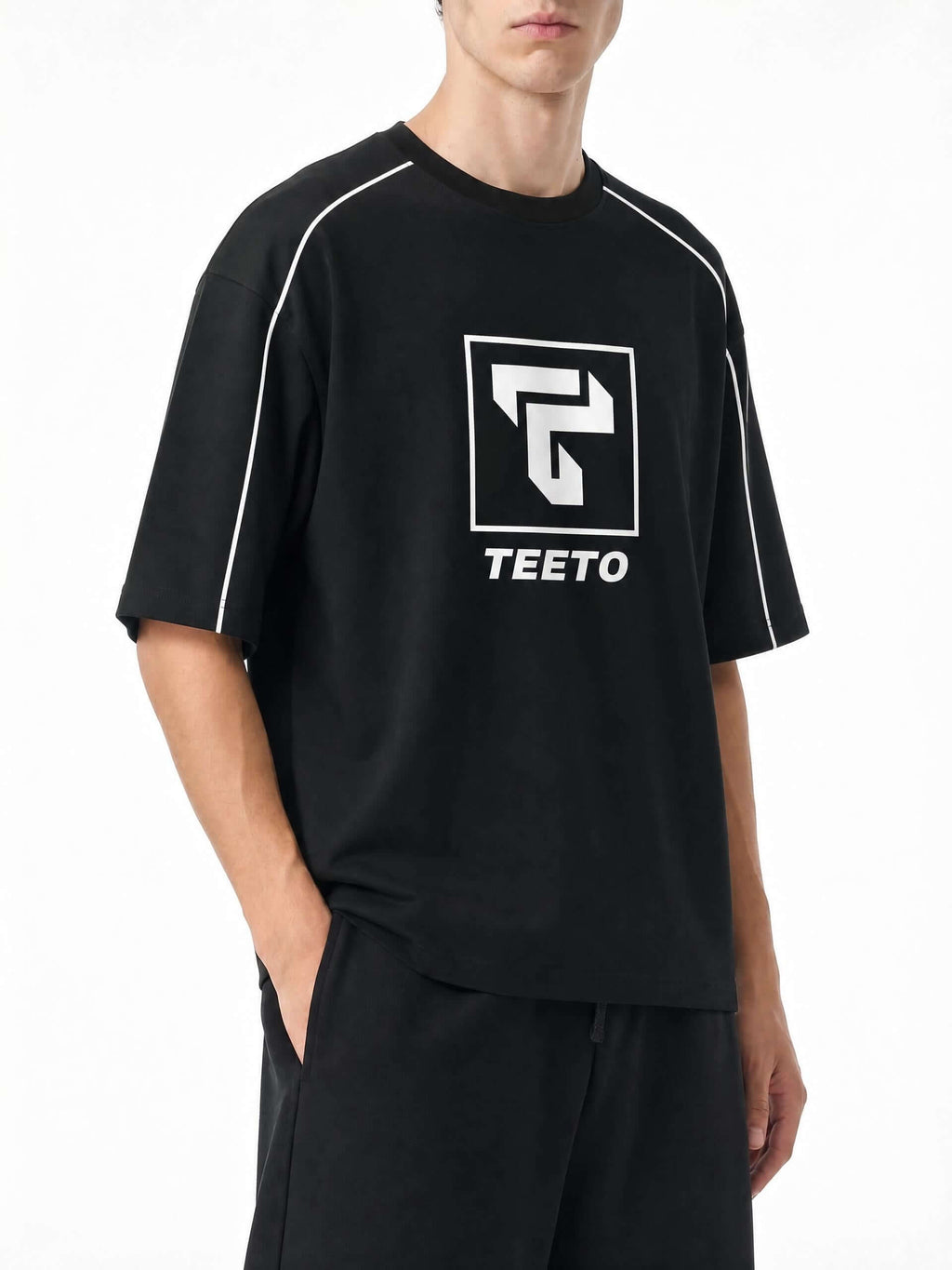 Teeto Heavyweight Boxy Piping T-Shirt in Black worn by a model, front three-quarter view.