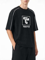 Teeto Heavyweight Boxy Piping T-Shirt in Black worn by a model, front three-quarter view.